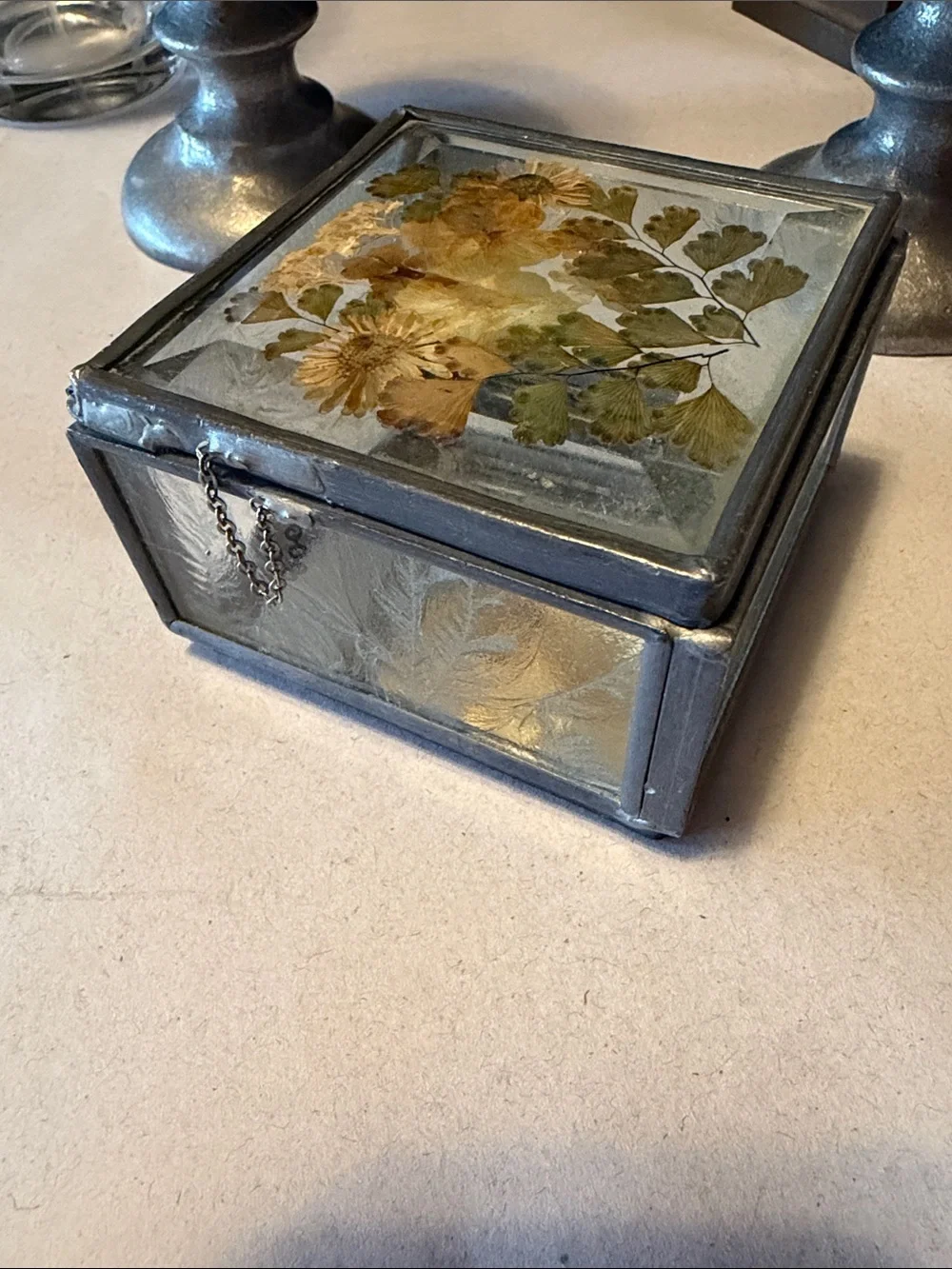 Vintage trinket box with metal edges and dried flowers on top. Mirror bottom.